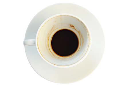 Dirty coffee cup with coffee grounds, on a plate, white backgroundの写真素材