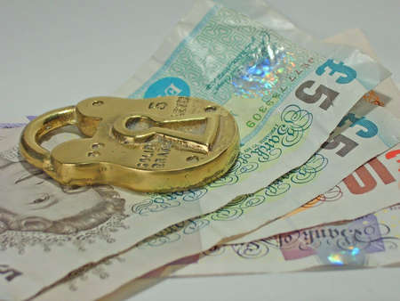 British bank notes under a brass padlockの写真素材