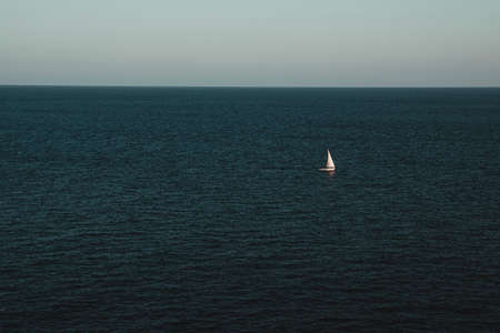 White sailing boat against sea horizonの写真素材