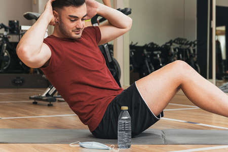 happy guy does sit-ups in the gymの写真素材