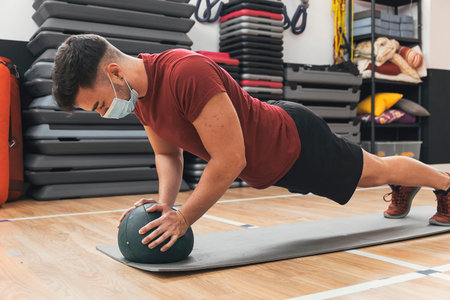 boy exercising with ball in the gymの写真素材