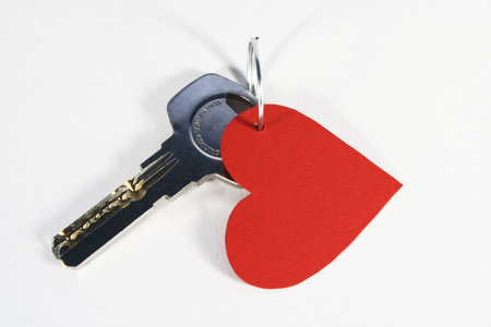 Modern key with a cutout red paper heart: Key to my heart concept