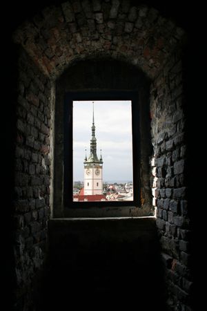 View of town hall tower of Olomouc through a church windowの写真素材