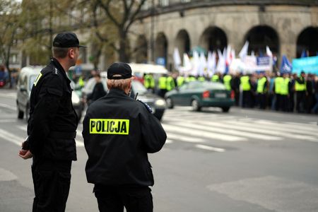 Police officers talking on a radio protecting an anti-government demonstration in Warsaw Poland on 7 October 2006 (Blue March by Platforma Obywatelska). Purposely taken with a shallow DOF not to detail faces.の写真素材