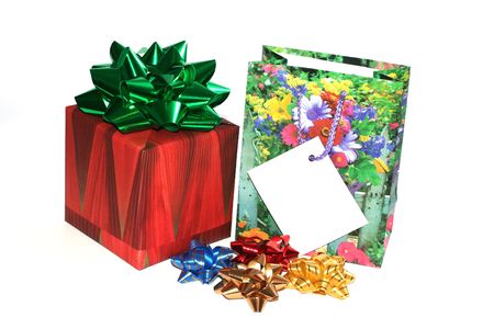 Christmas boxed gift with a ribbon and a gift bag with bow ribbons isolated on white with a gift card to put your message onの写真素材