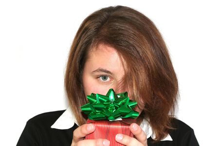 Beautiful girl holding up a wrapped gift: Christmas or other holiday conceptの写真素材