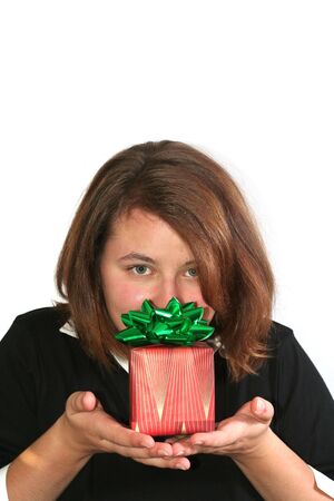 Beautiful girl holding up a wrapped gift: Christmas or other holiday conceptの写真素材