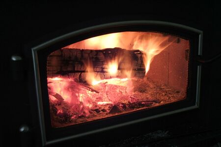 Wood stove with a blazing fire burning insideの写真素材