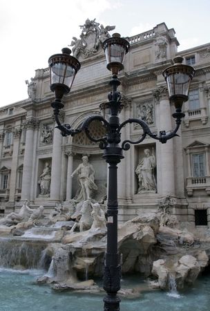 Rome's famous Trevi Fountain (Fontana di Trevi) with a typical lamppost in the foregroundの写真素材