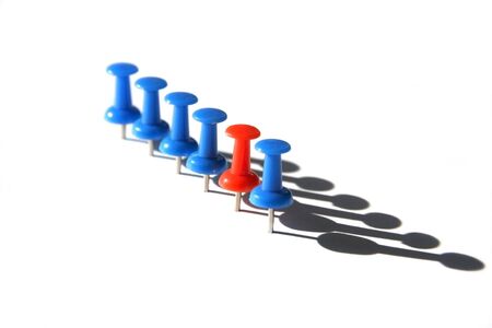 Red push pin in sharp focus standing out from the crowd of blue pinsの写真素材