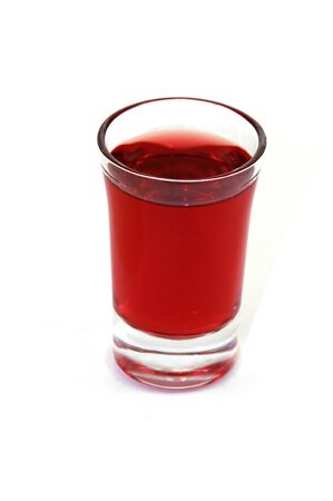 Isolated shot glass filled with red alcoholic beverageの写真素材