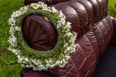 Flower crown on brown sofa, midsummer festival symbol, made of white plantsの写真素材