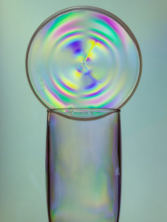 Empty champagne glass with plastic colorful circle, creative photo style, second trash life