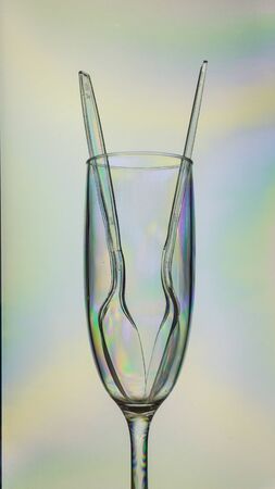 Empty colorful plastic champagne glass and two spoons, trash recycleの写真素材