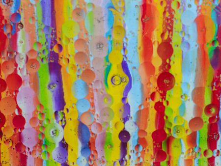 Oil bubbles in water glass dish, background colorfulの写真素材