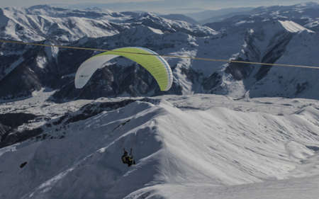 Gudauri, Georgia- February 2019: ski resort paragliding flying down mountainのeditorial素材