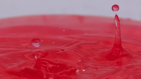 Pink color drop falling and splashing in water, creative forms freezingの写真素材