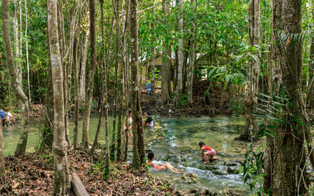 Krabi town, Thailand- March 28 2019: Emerald pool first level wterfall near entrance, citizen enjoy, water washed tree rootのeditorial素材