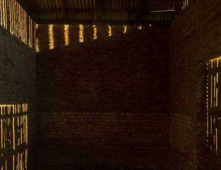Old farm building red brick room wall, sun shine from windowの写真素材