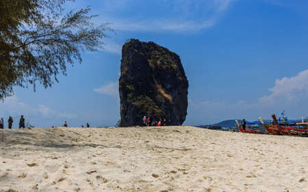 Krabi, Thailand- March 29 2019: white sand island beach rock, traditional long tail boatsのeditorial素材