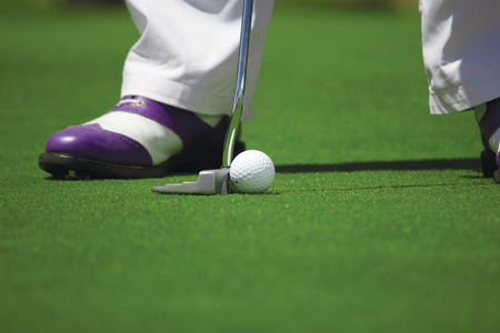 Close up of golf ball and shoes on a teeの写真素材