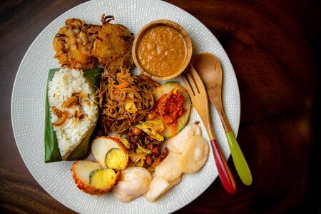 Asia Asian Indonesian Malaysia Singapore Traditional Food nasi uduk or nasi lemak coconut rice with chicken, noodle, eggs, cracker, vegetable frittersの写真素材
