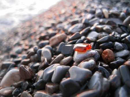 Orange glass laying on the sea shore