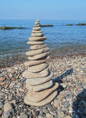 Balanced stones on the seashore summertime and blue sky backgroundの写真素材