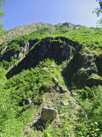 Caucasus mountains and forest under clear blue skyの写真素材