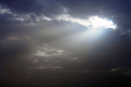 Sunbeams strike through the clouds and stormy weatherの写真素材