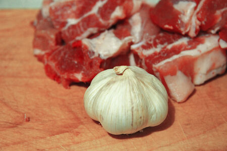 Fresh meat and fresh garlic laying on the kitchen deskの写真素材