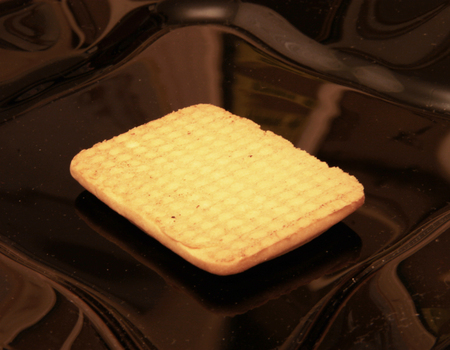 One cookie laying on the black plateの写真素材