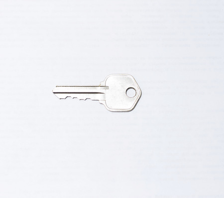 One metal flat key isolated on the white backgroundの写真素材