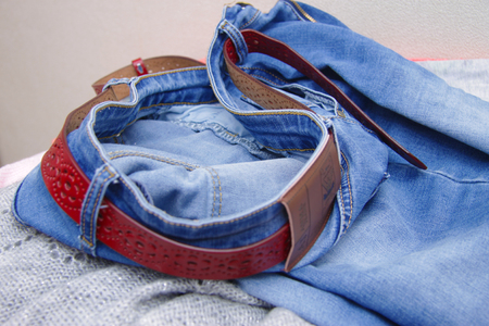 Quickly shot jeans blue denim fabric clothing textiles and a red leather beltの写真素材