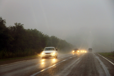 A Highway landscape with moving cars at daytime by misty roadのeditorial素材