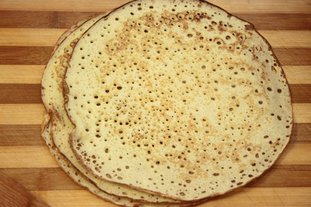 Stack of hot homemade pancakes on the wood cooking board
