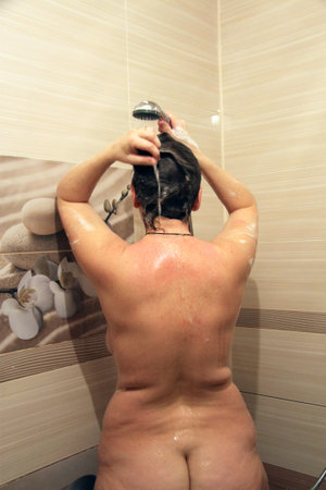 Attractive young woman washing her hairs in bath roomの写真素材