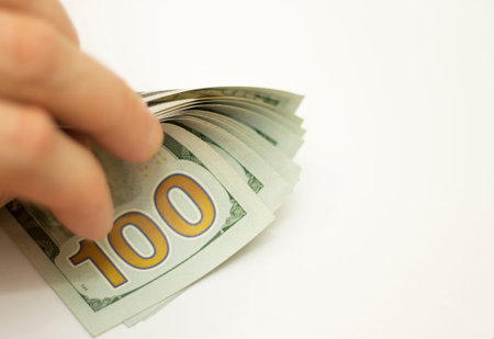Man paying by Stack Of new 100 Paper Dollars Usa isolated On The White Background