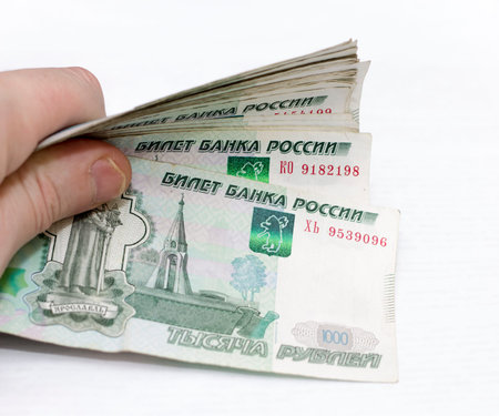 Man holding scattered russian 1000 rubles banknotes closeup isolated on the white background