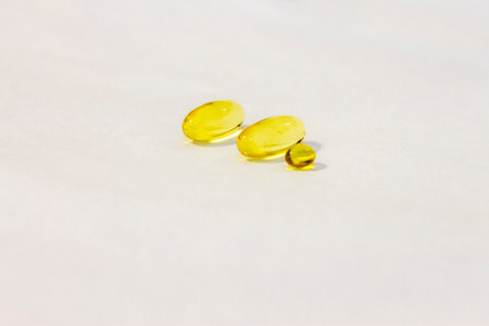 Capsule of vitamin D aka fish oil isolated on the white backgroundの写真素材