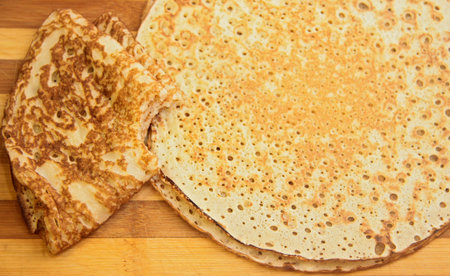 Stack of hot homemade pancakes on the wood cooking board