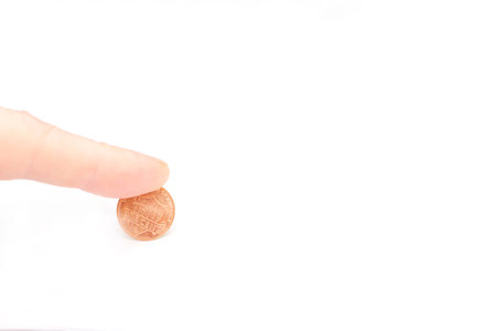 Mans finger press one modern cent of USA on the edge isolated on the white background
