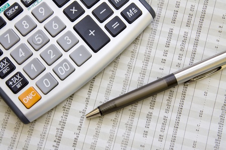A calculator, pen, and financial statement.の写真素材