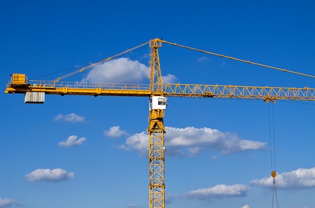 Construction crane against a blue sky with cloud background.の写真素材