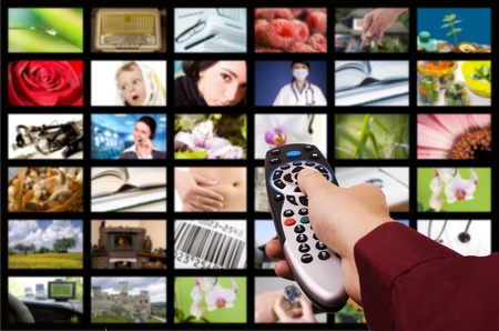 Close up of a hand holding a remote control with a television concept.の写真素材