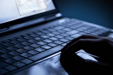Using a laptop, finger on touchpad and keyboardの写真素材