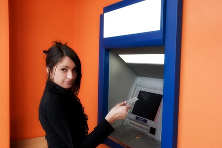 Woman withdrawing money from credit card at ATMの写真素材