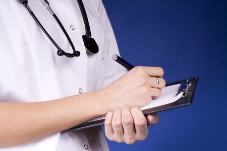 Healthcare professional, doctor or nurse, writing with a fountain pen on a paper over a folder の写真素材