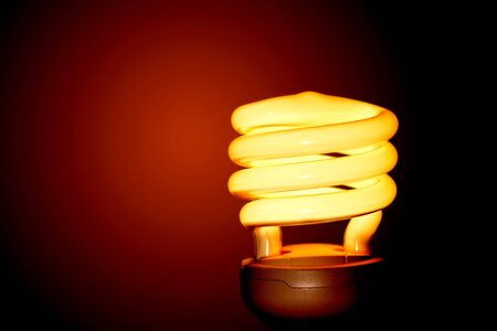 Energy saving light bulb on a red background の写真素材