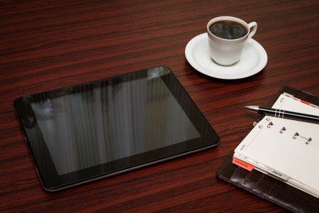 empty tablet and a cup of coffee on the deskの写真素材